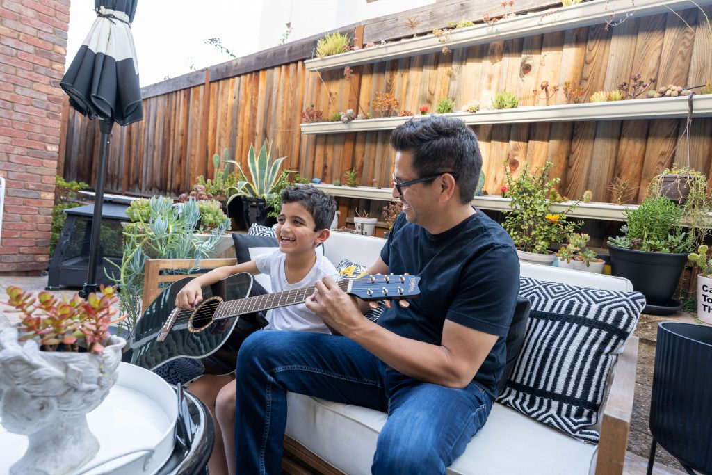 Dad teaching son to play guitar