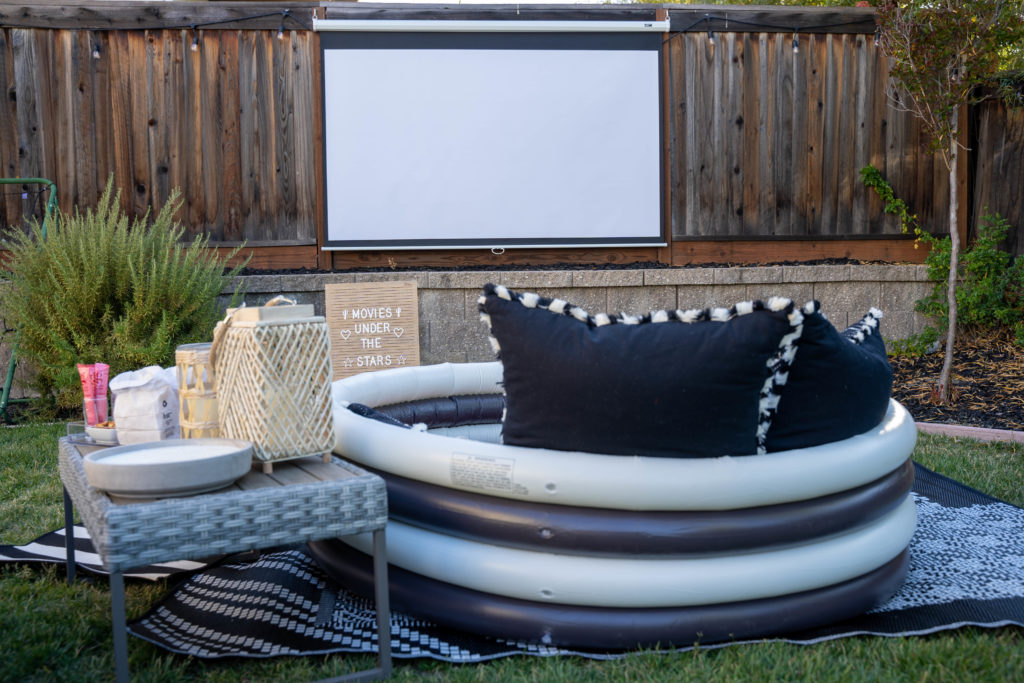 Outdoor movie set up using a pulldown screen, movie projector and inflatable pool
