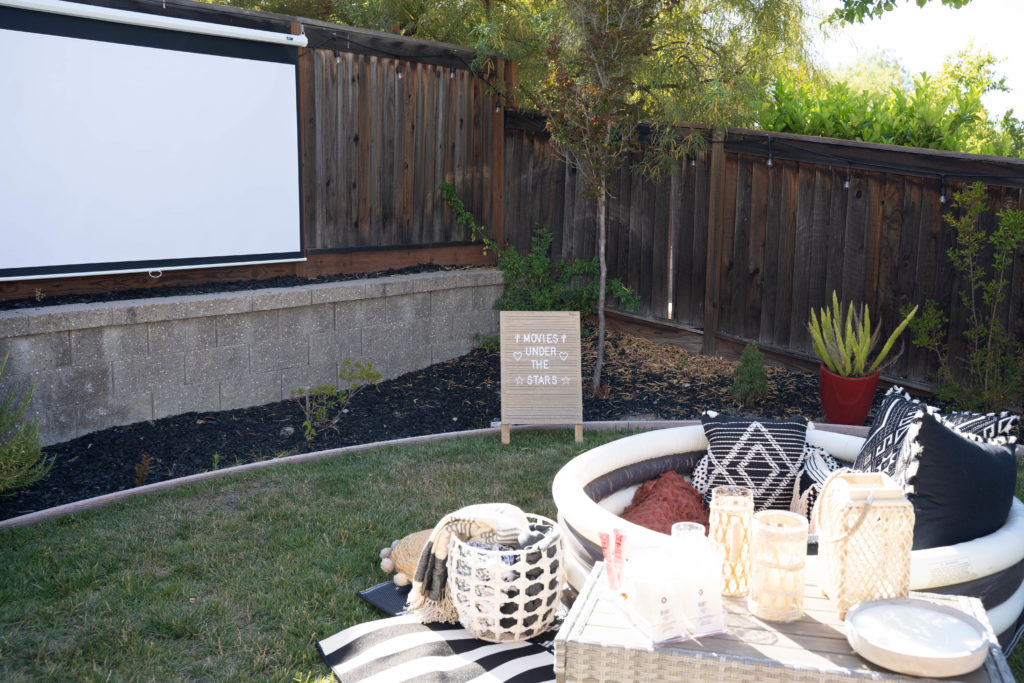 Outdoor movie set up using a pulldown screen, movie projector and inflatable pool