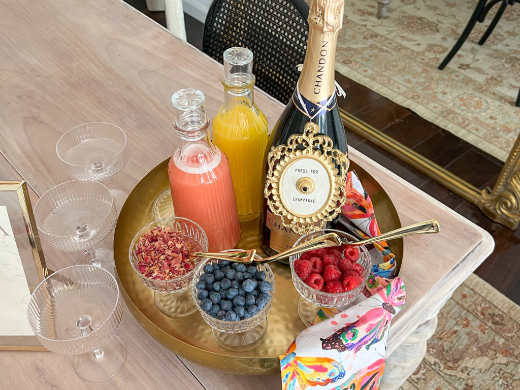 A mimosa bar set up with juices and garnish