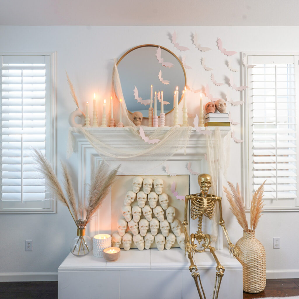 Halloween decorated mantle with neutral boho-styled DIY skull fireplace insert. Gold skeleton. Pink bats