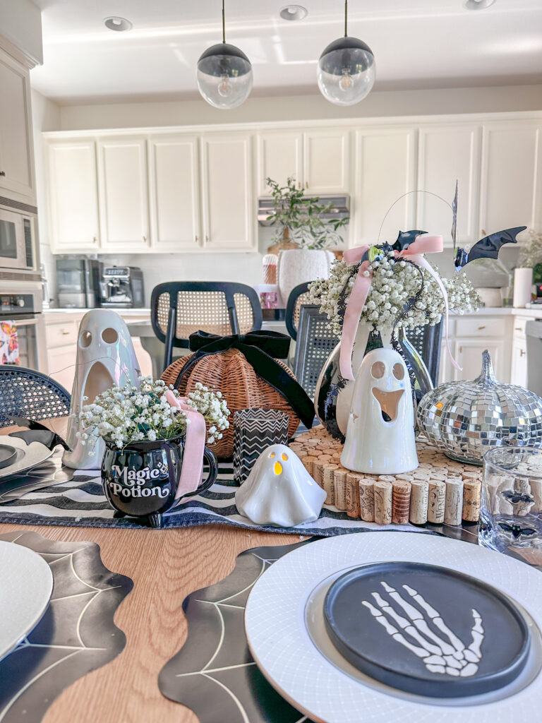 Halloween tablescape that is is black and white with ghosts and DIY flying bats