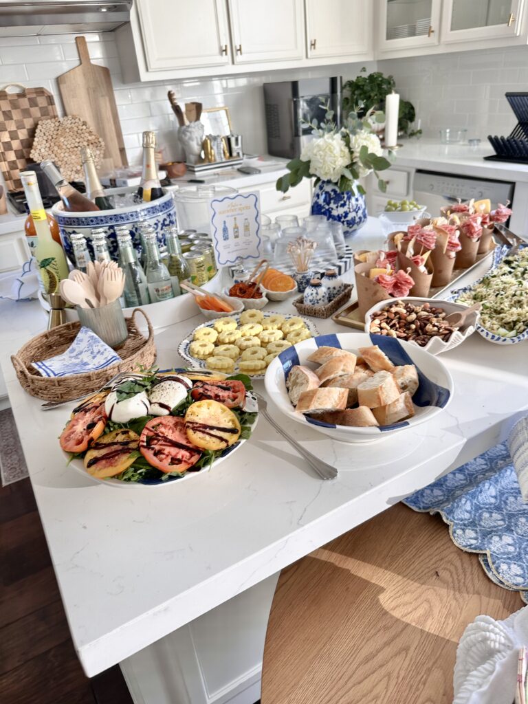 Coastal themed party with shell dishes. A countertop set up with chinoiserie planter used as an ice bucket for a DIY spritz bar. There is an infographic for how to make a summer spritz.