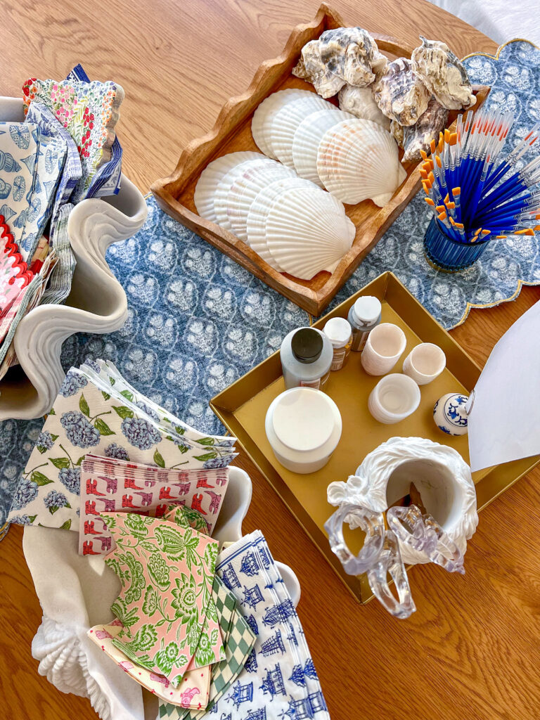 All the supplies needed for an oyster trinket dish- oyster and scallop shells, brushes, mod podge, decorative napkins, gold paint and scissors. 