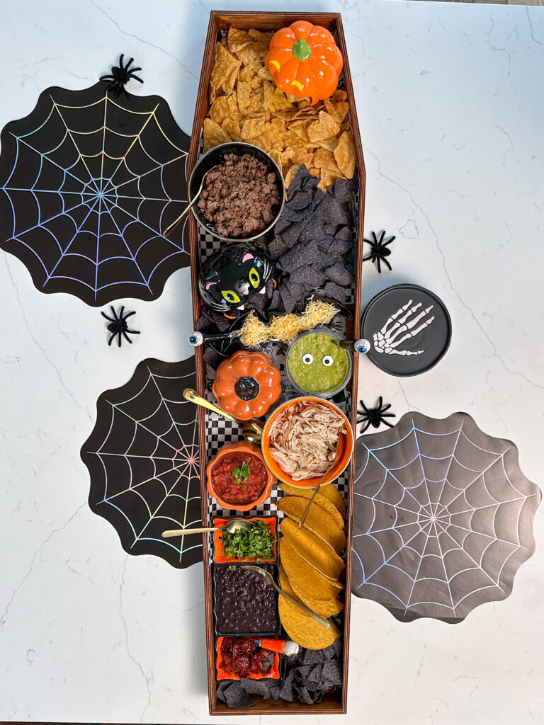 Halloween themed Nacho bar set up in wooden craft coffin on kitchen island 