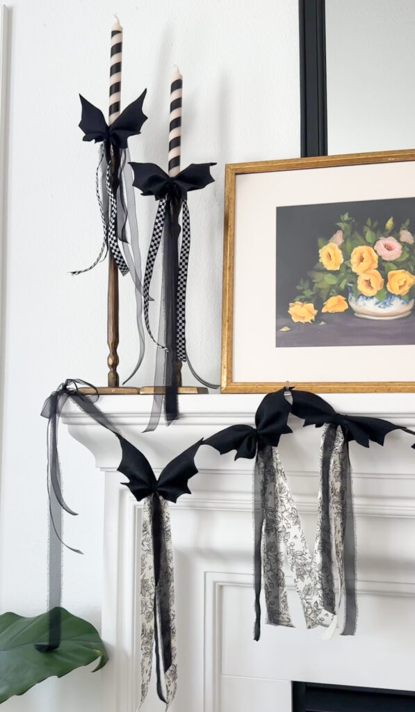 Dit bat bow garland halloween decorations on fireplace mantle and candlesticks