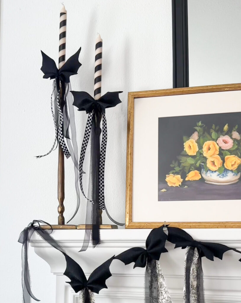 Dit bat bow garland halloween decorations on fireplace mantle and candlesticks