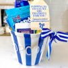 Teacher basket made for teacher appreciation back to school. It is a blue and white striped popcorn bucket filled with movie night essentials and a tag that says popping by to say "We are thankful for you! Enjoy your weekend with a movie night on us!"